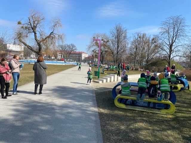 uczniowie odpoczywają na ławkach w parku
